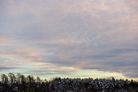 colorful sunset light over fields of snow in winter in countrysideの写真素材