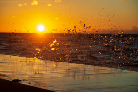 dark red sunset over sea in evening with broken cloudsの写真素材