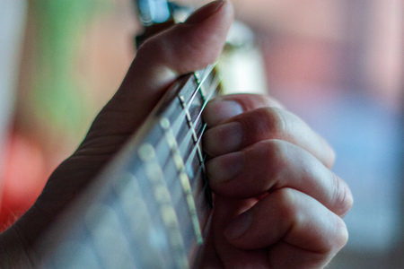 accoustic guitar strings with male hand playing chordsの写真素材