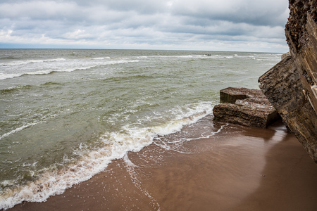 storm on the rocky sea beach with high waves and dramatic skyの写真素材