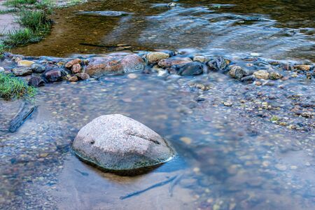 water texture with reflections and rocks on the bottom of stream. nature abstract