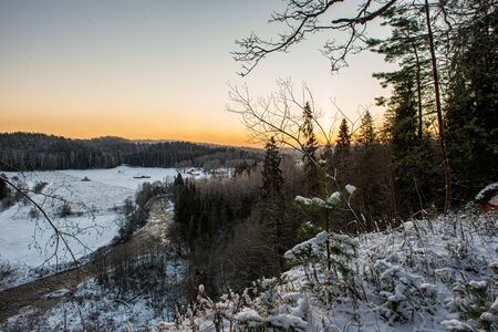 winter surise over countryside fields and forest in cold dayの写真素材