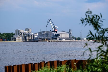 cargo shipping terminals in Riga, Latvia with high wind and dust flying over with cranes and ships.の写真素材