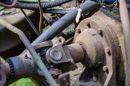vintage retro tractor rusty details close up. gearbox, levers, viring and mechanical arms with rust and paint leftovers in sunny dayの写真素材