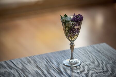 flowers in the glass vase in apartment with shadows on the wall