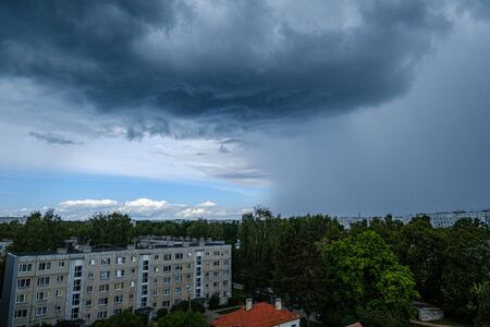 dramatic rain clouds over city rooftops in autumnの写真素材