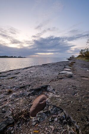 frozen sea beach with sand and first snow in cloudy day in winterの写真素材