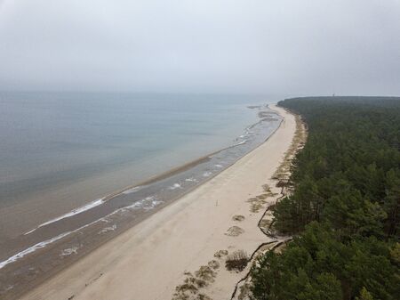 seaside beach with water covered in fog mist. drone aerial imageの写真素材