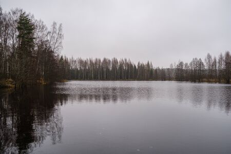 small forest lake in countryside with water reflections in calm water. place for meditationの写真素材