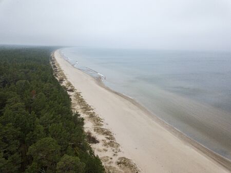 seaside beach with water covered in fog mist. drone aerial imageの写真素材