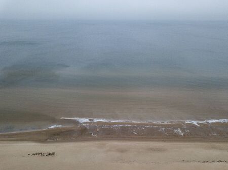 seaside beach with water covered in fog mist. drone aerial imageの写真素材