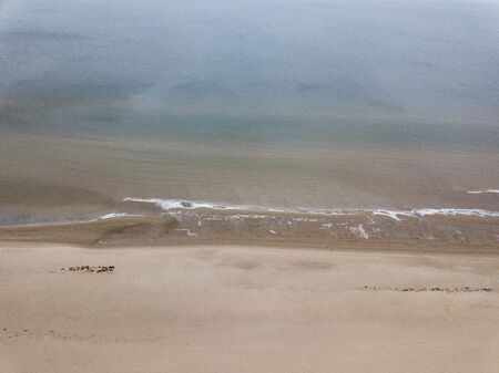 seaside beach with water covered in fog mist. drone aerial imageの写真素材