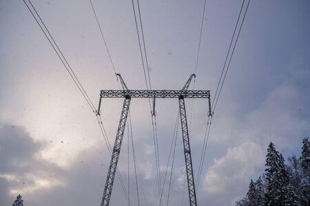 power line in winter day  with heavy snow fall