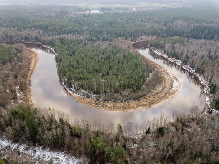River in winter forest with green trees from above. Aerial drone image of river Gauja in Latvia.の写真素材