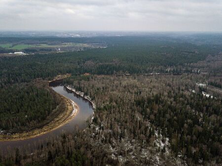 River in winter forest with green trees from above. Aerial drone image of river Gauja in Latvia.の写真素材