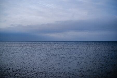 empty sea beach in autumn with some bushes and dry grass. water in perspectiveの写真素材