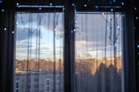 apartment windows in autumn with christmas decorations and winter sun on the street. dull tonesの写真素材