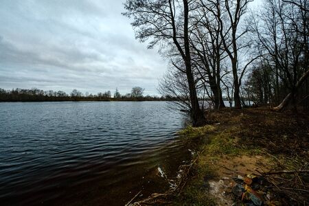 autumn river with flooded shore with trees in the waterの写真素材