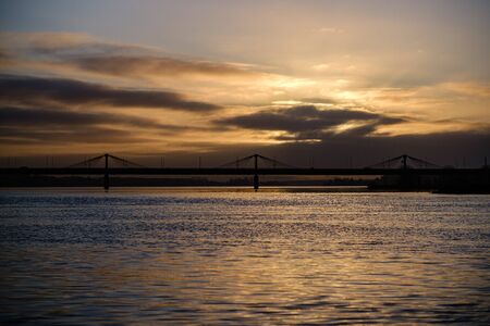 sunset over the city with dark tree trunk silhouettes in front. autumnの写真素材