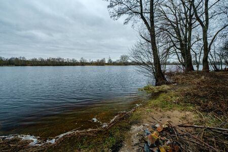 autumn river with flooded shore with trees in the waterの写真素材
