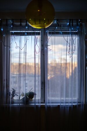 apartment windows in autumn with christmas decorations and winter sun on the street. dull tonesの写真素材