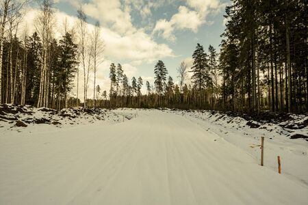 construction site of new road in forest in winter with snow and mudの写真素材