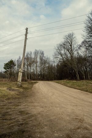 gravel dirt road in the forest. late autumn in Latviaの写真素材