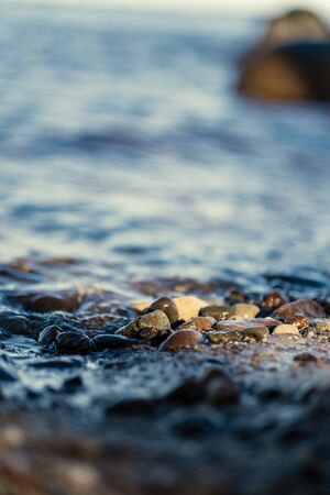waves crushing on the rocks on beach in sunny day with blue sky and clear water on the sand texture. pebblesの写真素材