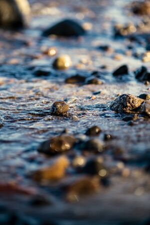 waves crushing on the rocks on beach in sunny day with blue sky and clear water on the sand texture. pebblesの写真素材