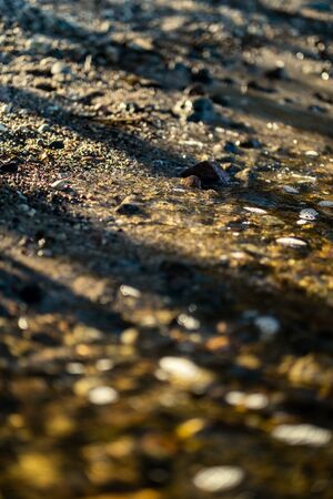 waves crushing on the rocks on beach in sunny day with blue sky and clear water on the sand texture. pebblesの写真素材