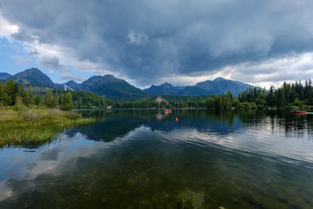 autumn nature reflection in lake of Strbske Pleso in Slovakia surrounded by trees and mountainsのeditorial素材