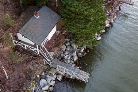 rocky coastline in Finland with few pine trees and calm water in summerのeditorial素材