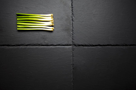 A selection of spring onions of charcoal base. Onions cut and cleaned for uniformityの写真素材