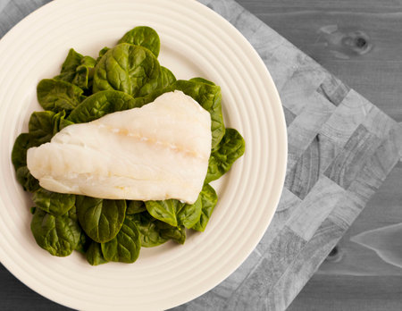 Simple Lunch of Organic Spinach on White Plate and placed on Wooden Chopping Board