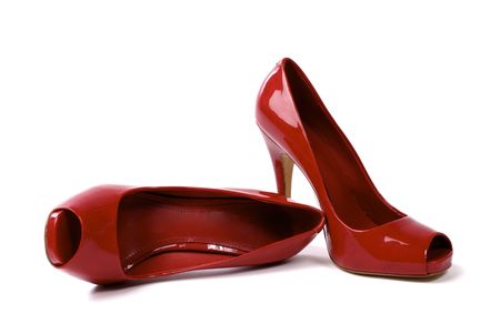 A pair of red women's high-heel shoes against white background, one shoe standing, one shoe lyingの写真素材