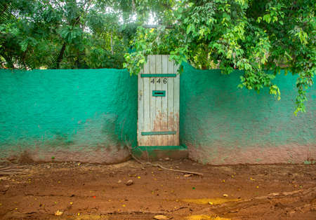 rustic green wall with wooden door in rural streets of brazilの写真素材