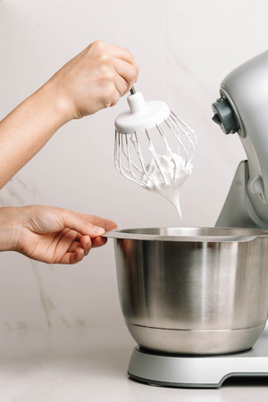 The mixer whisk heaps eggs and sugar to make marshmallow. Close-up. Homemade marshmallow recipeの写真素材
