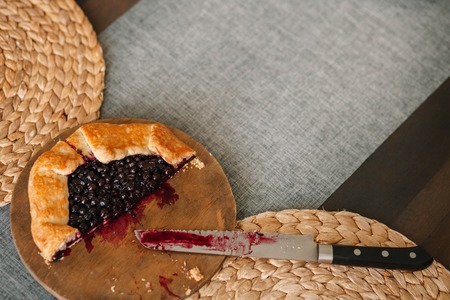 Cutted galette with seasonal berries. Flat lay crispy summer berry pie on a gray-blue background with copy space.の写真素材