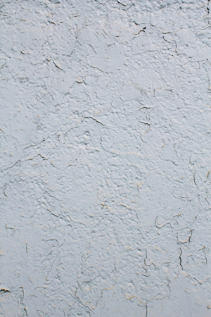Texture of a wall painted with cracked white paint backgroundの写真素材
