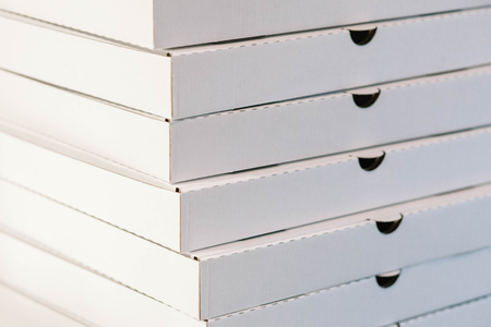 A large stack of white empty pizza boxesの写真素材