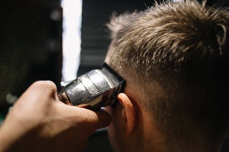 Barber barber cuts a man in a barbershop with a hairdresser close upの写真素材
