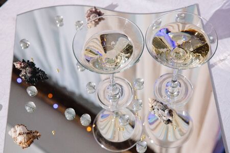 Champagne glasses. Wedding slide champagne for bride and groom outdoors. Colorful glasses with champagne. Catering bar for celebration.の写真素材