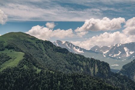 View of the mountain meadow and mountain. Beautiful clouds and mountain in a blue haze. Travel conceptの写真素材