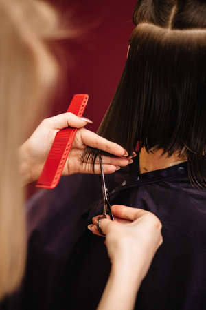 Professional hairdresser woman with comb and scissors in her hands.の写真素材