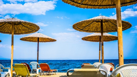 Beautiful Seascape With Beach Umbrellas And Sunbeds in Stavros, Greeceの写真素材