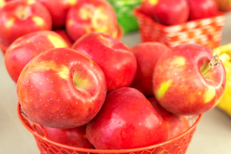 Red apples in a basket on the counter of a grocery store.の写真素材