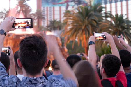 Rear view of a group of people taking a selfie with a mobile phone.の写真素材