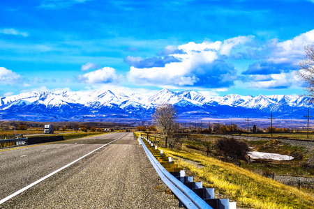 photo of mountains in the background off a Montana highwayの写真素材