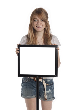 Beautiful young woman stands behind sign on standの写真素材