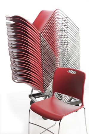 Stack of vibrant orange plastic chairs for a conferenceの写真素材